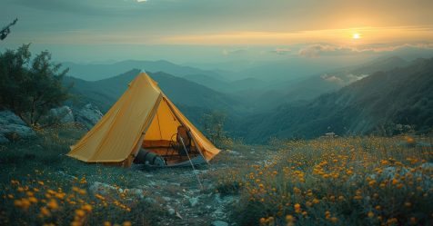 man sitting inside an orange tent and looking at a beautiful mountain landscape during sunset while camping, an adventurous travel concept ERP Einführung